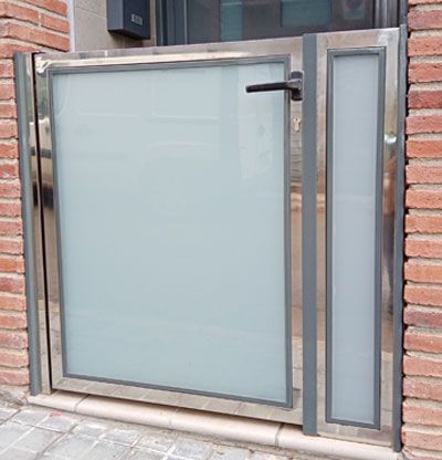 Puerta plancha acero gris con entrada luz cristal