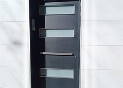 Puerta vivienda plancha acero gris con entrada luz cristal. tallermetalico.com