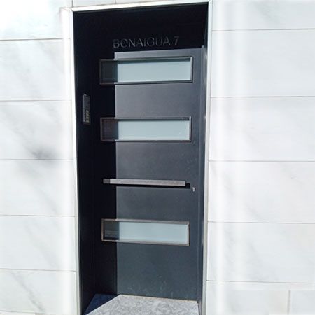 Puerta plancha acero gris con entrada luz cristal
