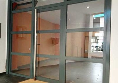 Puerta hierro gris acristalada para comunidad de tallermetalico.com , construcciones metálicas en el Vallès