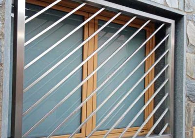 reja acero inoxidable tubular cuadrado diagonal en ventana calle tallermetalico.com