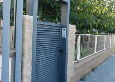 Puerta metálica entrada calle gris. tallermetalico.com